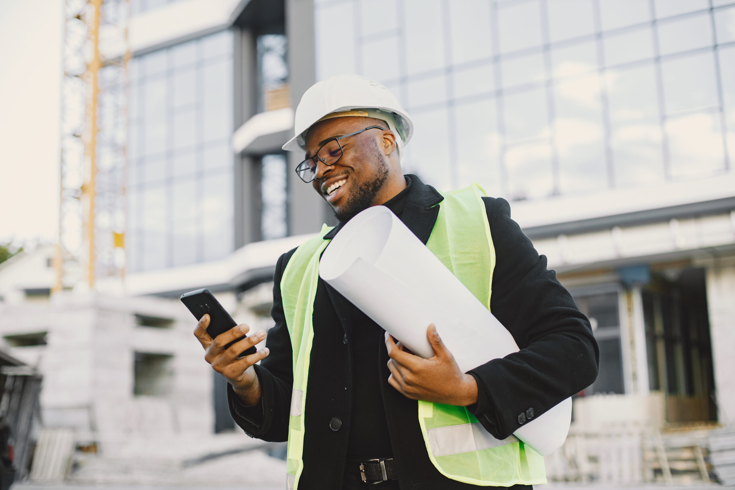Smiling construction engineer with blueprints